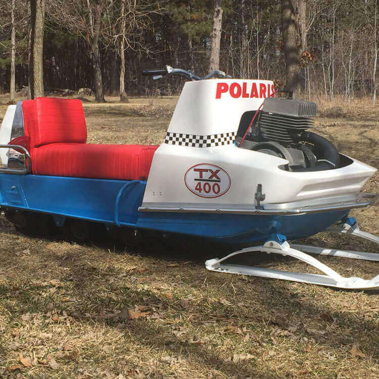 Vintage white snowmobile with a red seat