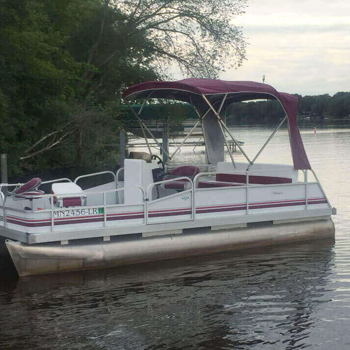 White pontoon with a burgundy canopy